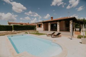 a swimming pool in front of a house at Villa Daisy in Tar