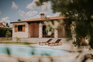 a house with two chairs next to a swimming pool at Villa Daisy in Tar