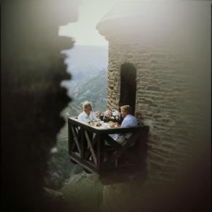 people sitting at a table in front of a river at Burghotel auf Schönburg in Oberwesel