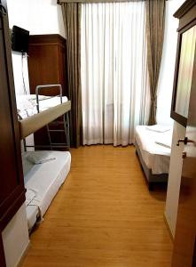 Cette chambre comprend 2 lits superposés et une fenêtre. dans l'établissement Guesthouse Alex II, à Rome
