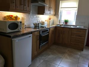 uma cozinha com um micro-ondas e um fogão forno superior em Ard Cashel, Barrack Brae em Dungloe
