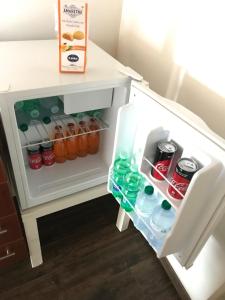 an open refrigerator filled with drinks and soda at Palazzo Sum Avola in Avola