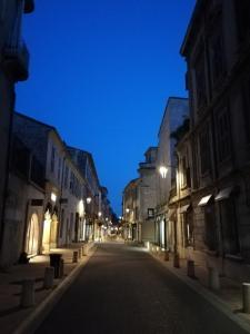une rue de ville vide la nuit avec des lumières dans l'établissement Studio centre avec terrasse, à Avignon