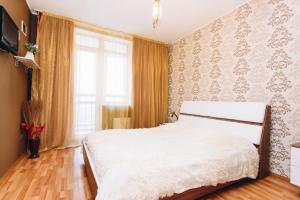 a bedroom with a white bed and a window at Guest apartments Alesia in Yekaterinburg