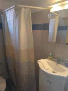 a bathroom with a shower curtain and a sink at Pefka Armenistis in Armenistis