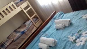 dwa łóżka piętrowe z ręcznikami na niebieskiej prześcieradle w obiekcie NaBaDa w mieście Tsʼageri