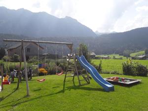 a playground with a slide and a swing set at Appartment Hirschberg in Bizau