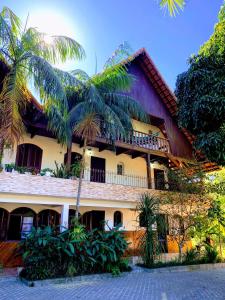 a building with a palm tree in front of it at Chalé do Recanto in Lumiar