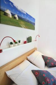 a bed with two pillows and a picture on the wall at Blackbird House Štanjel Historic Center in Štanjel