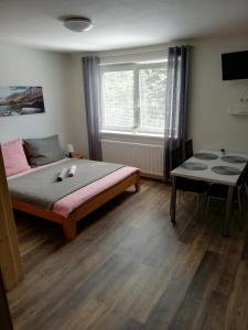Schlafzimmer mit einem Bett, einem Tisch und einem Fenster in der Unterkunft Apartmany Agatha in Loučná nad Desnou