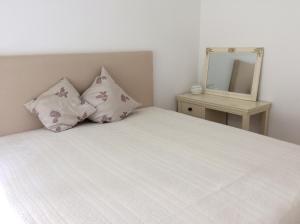 sypialnia z łóżkiem z 2 poduszkami i lustrem w obiekcie Kurhaus Apartment King Size Bett 180x200 w mieście Bad Harzburg