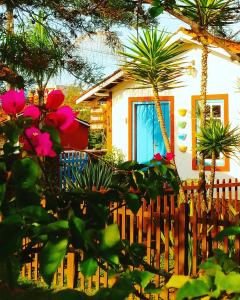 a house with a wooden fence and some flowers at Vila das Artes Chales in Lavras Novas
