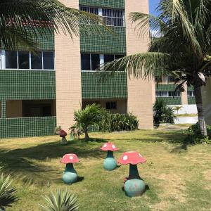 a group of mushrooms in the grass in front of a building at Apartamento na Praia in Fortaleza