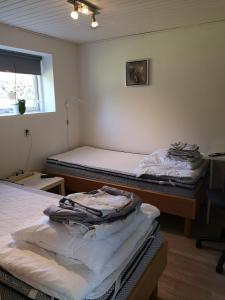 een kamer met 2 bedden en een raam bij Commuter room for one or two people in Munkebo