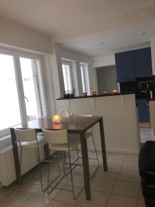 eine Küche mit einem Holztisch und Stühlen im Zimmer in der Unterkunft 2 slaapkamer appartement op de zeedijk van Oostende. in Ostende
