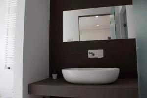 ein Badezimmer mit einem weißen Waschbecken und einem Spiegel in der Unterkunft Xenia, B&B Soverato in Soverato Marina