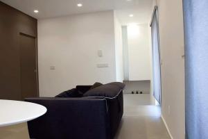 ein Wohnzimmer mit einem schwarzen Sofa und einem Tisch in der Unterkunft Xenia, B&B Soverato in Soverato Marina