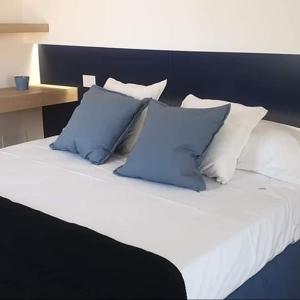 a bed with blue and white pillows on it at Xenia, B&B Soverato in Soverato Marina