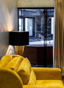 a living room with a yellow couch and a tub at La Suite Boutique Hotel in Tirana
