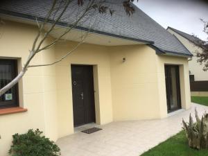 a detached house with a black door at Maison d’hôtes du Clos de Kério in Guidel