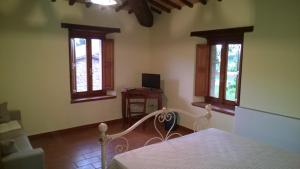 1 dormitorio con 1 cama y 2 ventanas en Cerqueti agriturismo, en Baschi