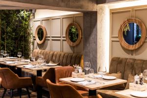 a restaurant with tables and chairs and plants at La Suite Boutique Hotel in Tirana