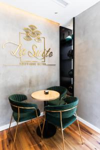 a table with green chairs in a restaurant at La Suite Boutique Hotel in Tirana