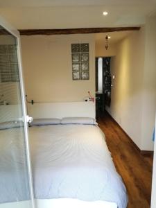 a large white bed in a room with wooden floors at La casa di Gigioz in Sestri Levante