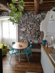a kitchen with a table and chairs in front of a stone wall at La casa di Gigioz in Sestri Levante
