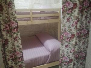 a small bunk bed with pink sheets and flowers at Trulli Manuela 1 in Locorotondo