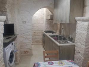 a kitchen with a sink and a washing machine at Trulli Manuela 1 in Locorotondo