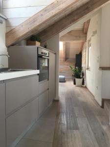 eine Küche mit weißen Schränken und einer Holzdecke in der Unterkunft Il Riposo del Gladiatore in Aosta