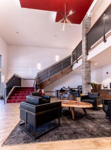 a living room filled with furniture and a large window at Hotel Kelowna & Conference Centre in Kelowna