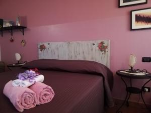 a bedroom with a bed with pink walls at B&B LA Garzetta in Adria