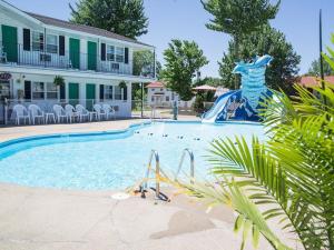 a pool with a water slide in front of a house at Colonial motel in Wisconsin Dells