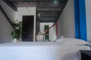 Un dormitorio con una gran cama blanca y una escalera en Apartamento 12 Cali Sur, en Cali