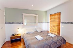 a bedroom with a large bed and a mirror at Newcastle Harbourside Terraces in Newcastle