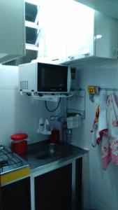 eine Küche mit einer Spüle und einer Mikrowelle in der Unterkunft Apartamento Copacabana 8 in Rio de Janeiro