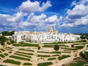 a large white building with a garden in front of it at Trulli Manuela 1 in Locorotondo