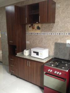 a kitchen with a red stove and a microwave at TJ Cottage in Ilorin