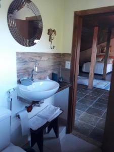 uma casa de banho com um lavatório, um espelho e uma cama em Suite da Fernanda em Vila Velha