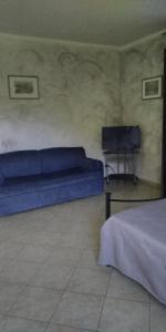 1 dormitorio con 1 cama azul y TV en b&b Casa Regina, en Stroncone