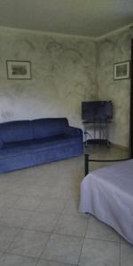 a bedroom with a blue bed and a television at b&b Casa Regina in Stroncone
