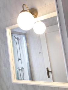 a bathroom with two lights and a mirror at Bright Apartment steps from Plaza de Toros and Wizink Center in Madrid