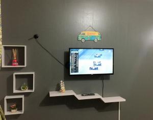 a flat screen tv hanging on a wall at Linda Vista e Som das Ondas in Caraguatatuba