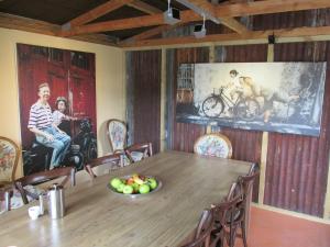 a dining room with a wooden table and a painting on the wall at Designer Cottage in Christchurch