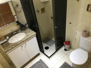 a bathroom with a shower and a sink and a toilet at Encantos do Porto da Barra in Salvador