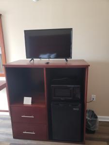 a wooden entertainment center with a flat screen tv on top at Conway Express Inn in Conway