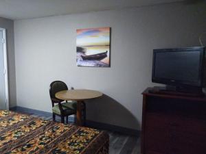 um quarto de hotel com uma cama, uma televisão e uma mesa em Tourist Inn em Absecon