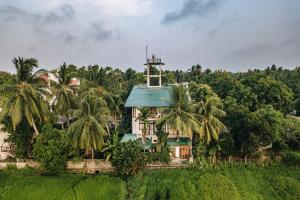 a house with a blue roof and palm trees at Heaven Upon Rice Fields in Anuradhapura